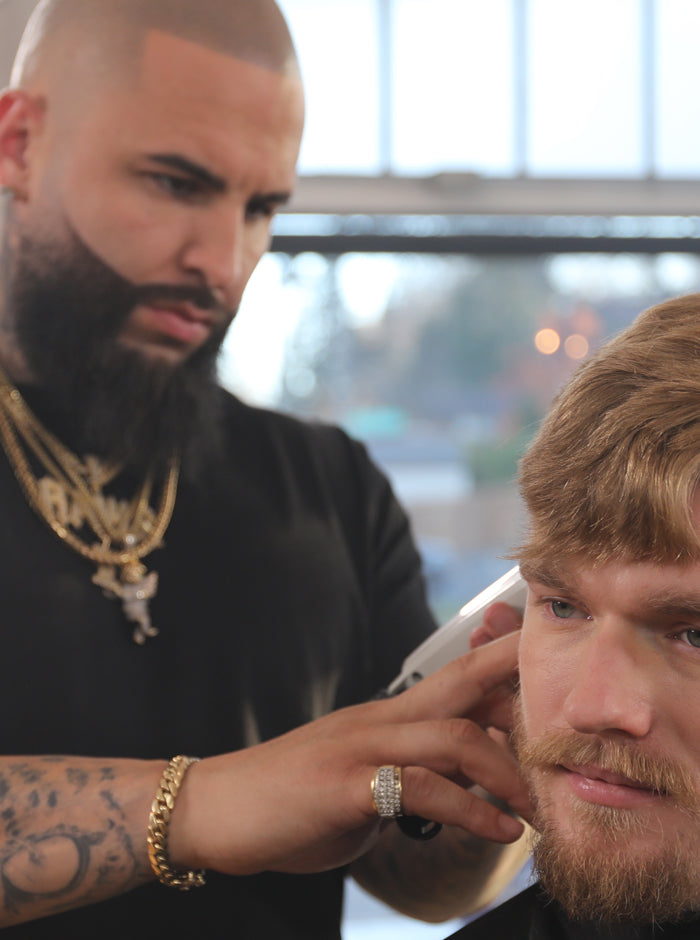 Friseur trimmt Bart mit Clipper