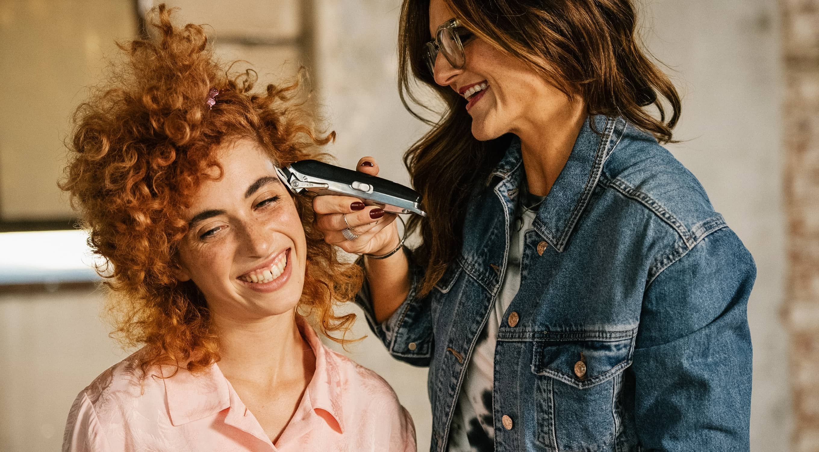 Friseurin trimmt Haare mit Clipper